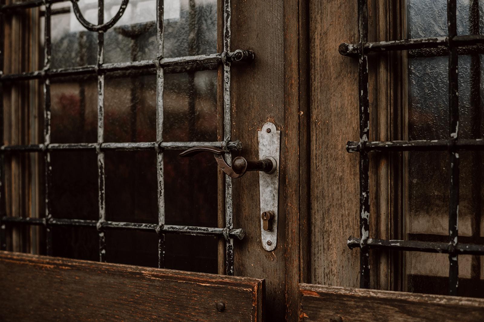 Detailaufnahme einer alten Türe mit Gitter vorm Fenster