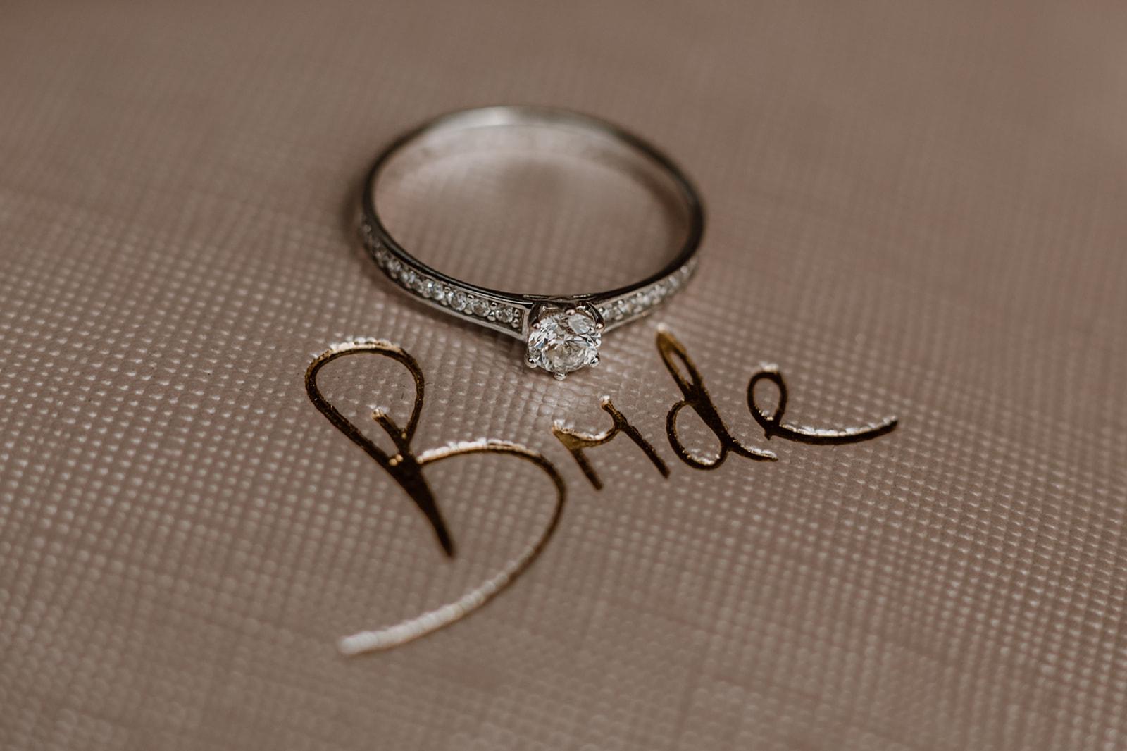 Verlobungsring auf Bride-Schriftzug liegend