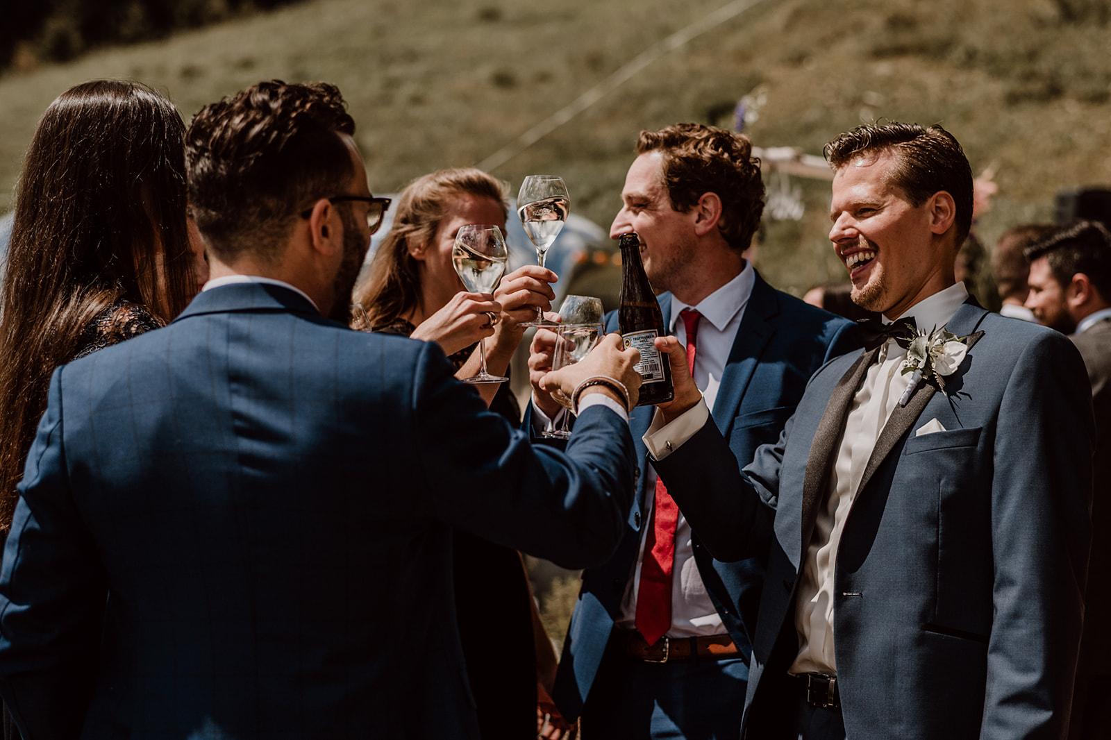 Bräutigam und Gäste stoßen mit ihren Getränken an